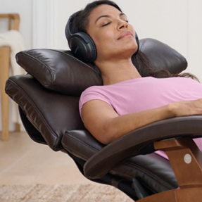 Woman relaxing in a massage chair in a bedroom setting