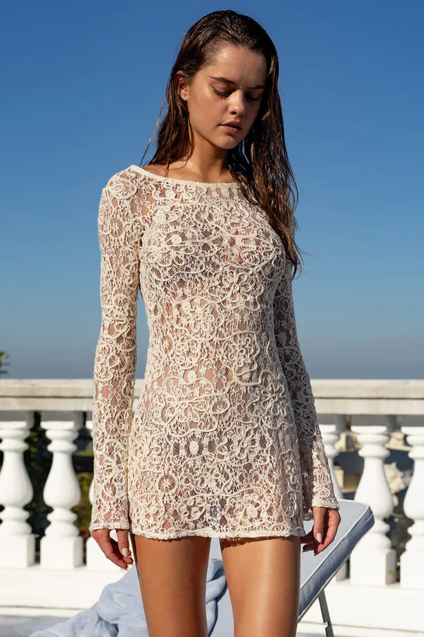 Model in Beach Bunny's Dream Catcher crochet mini dress on a sunny terrace