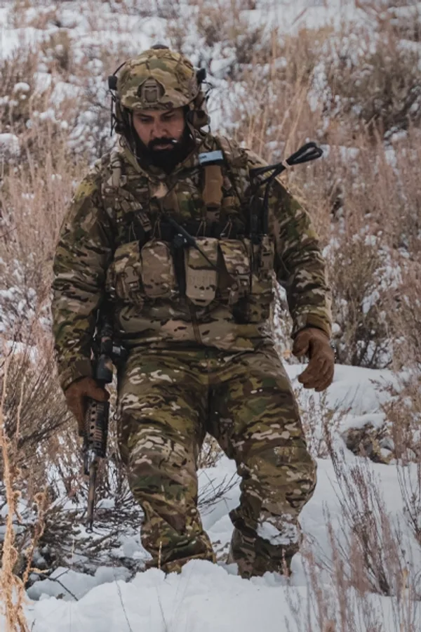 Soldier in Beyond cold-weather layers walking through snow and dry brush