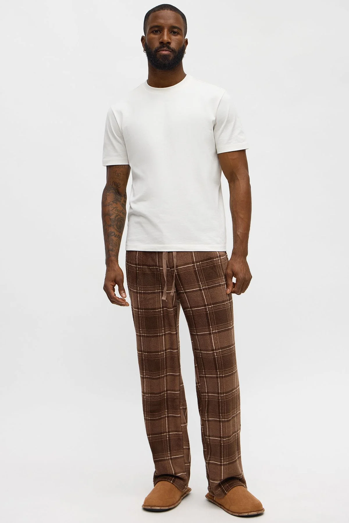 Model in a white tee and brown plaid trousers