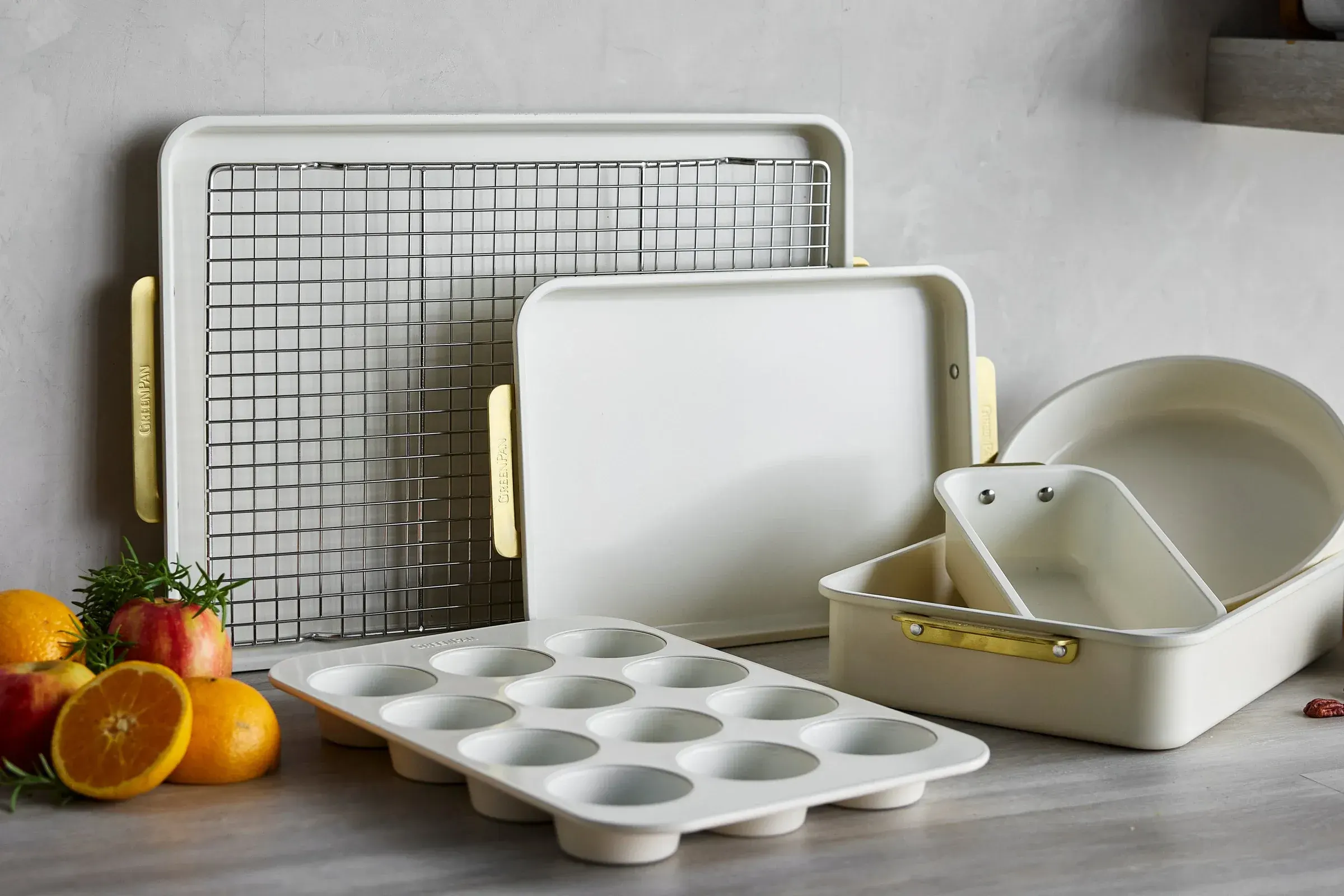 GreenPan cream bakeware set with sheet pans, a muffin tin and a roasting pan on a kitchen counter