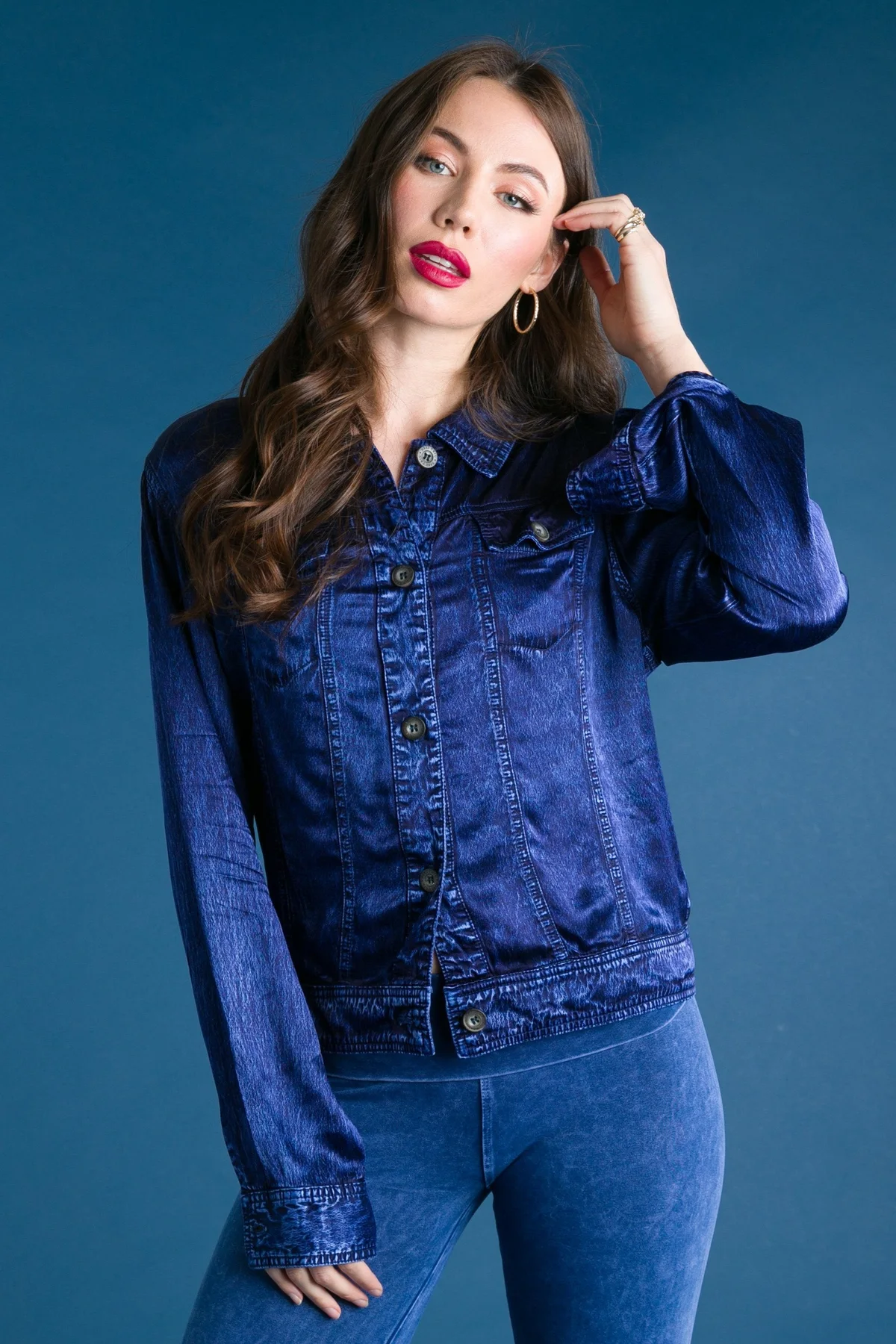 Model in a blue Hard Tail button-front jacket and leggings against a blue backdrop