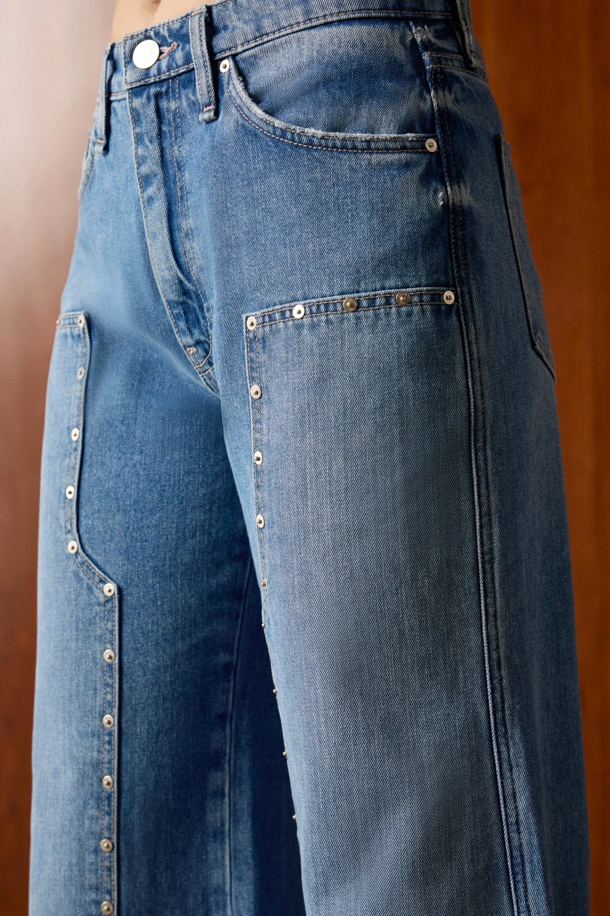 Close-up of light-wash Hudson wide-leg jeans with stud detailing