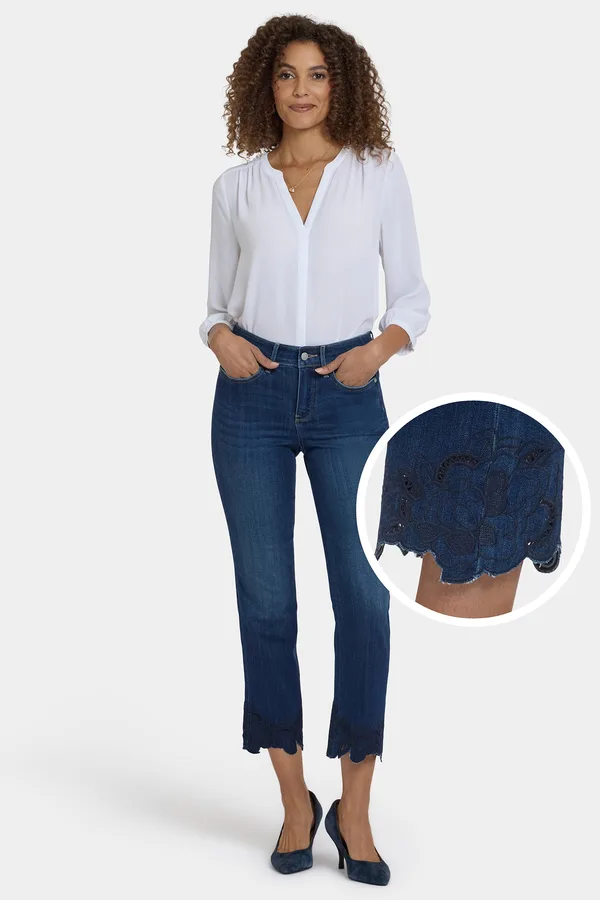 A model wearing NYDJ dark-wash embroidered ankle jeans