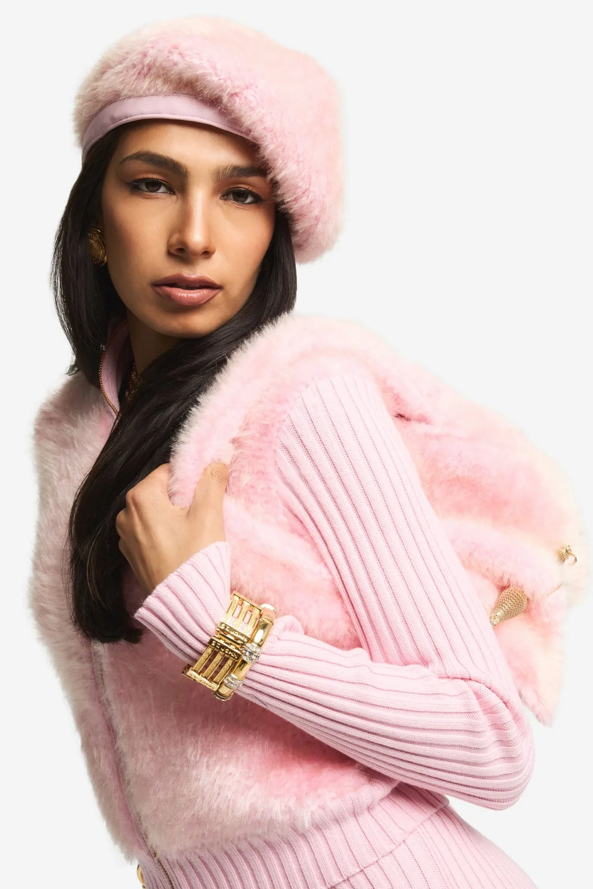 Model in a pink St. John ribbed-knit zip cardigan with faux-fur trim and a matching beret