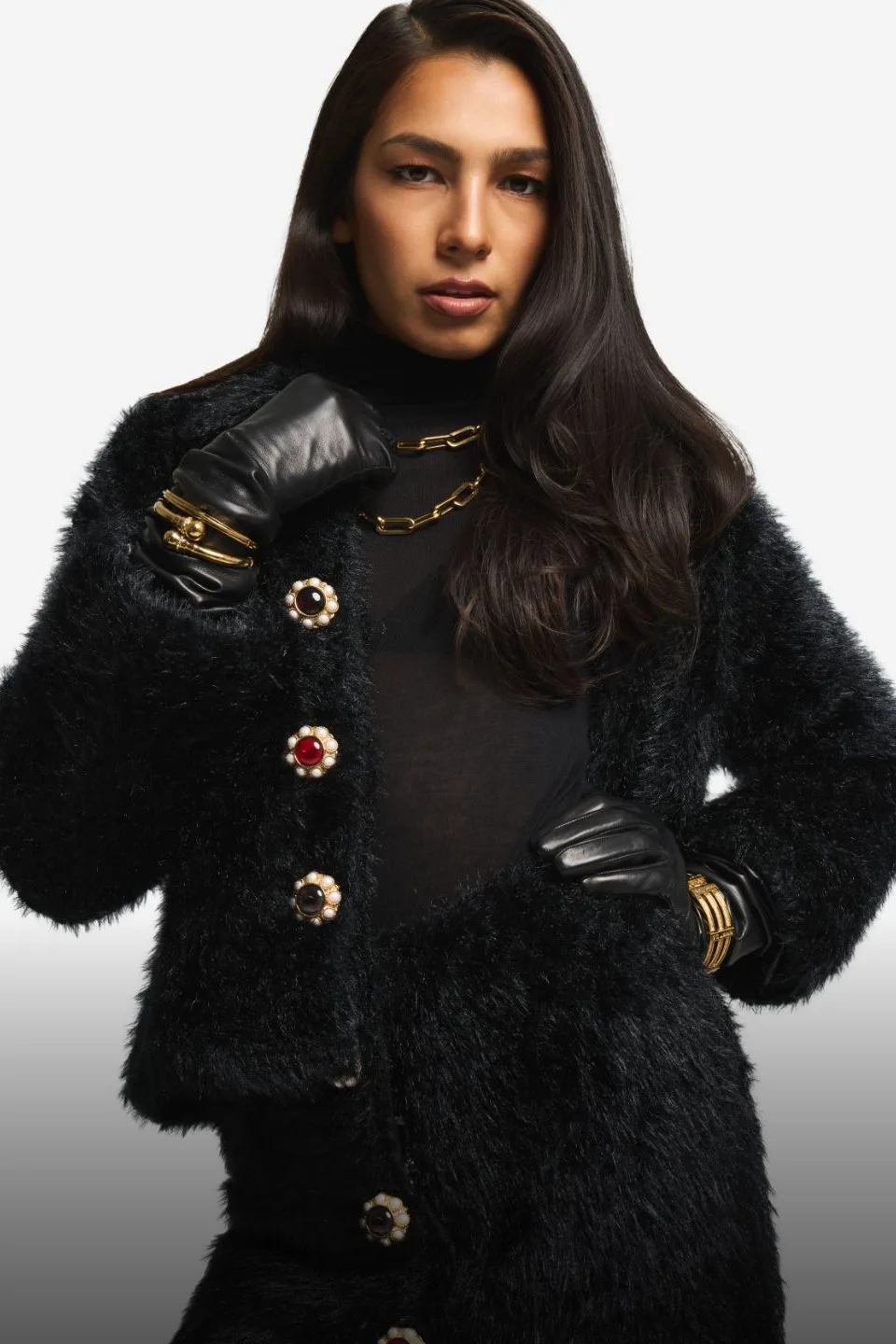 Model in a black St. John faux-fur jacket with jeweled buttons and leather gloves