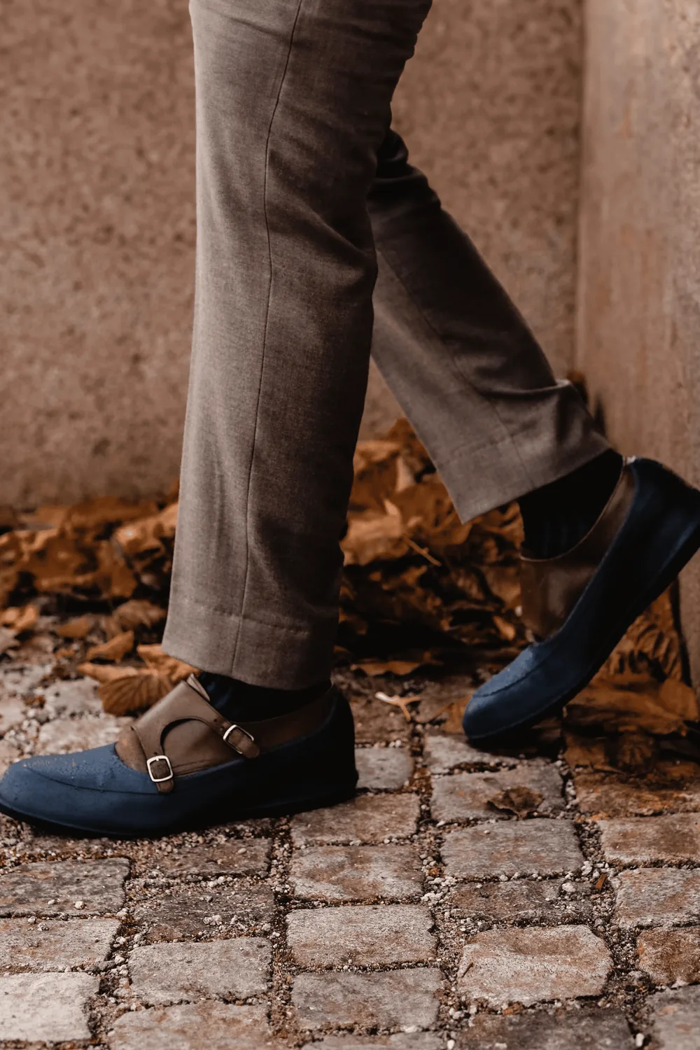 A SWIMS galosh worn over a dress shoe on cobblestones