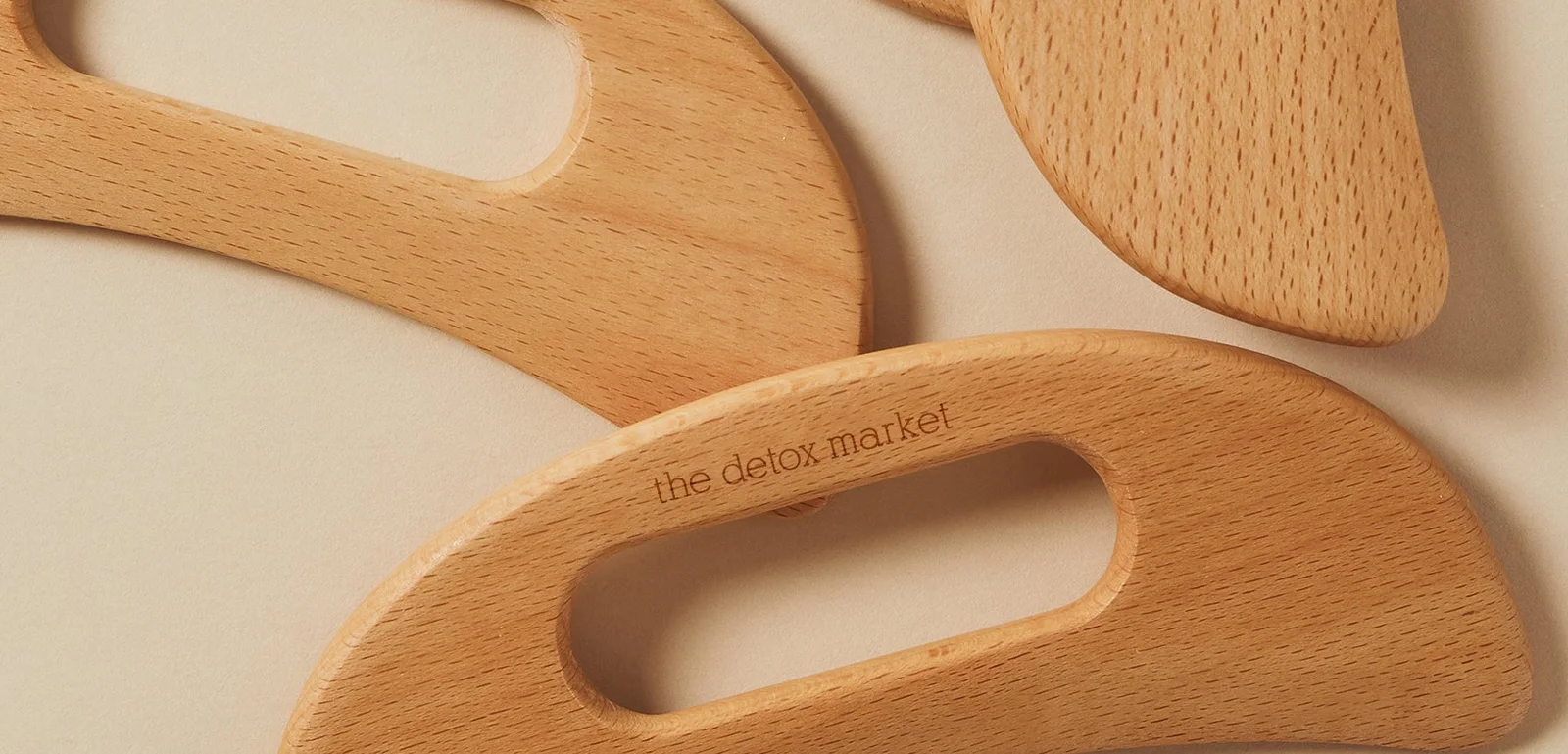 The Detox Market wooden gua sha tools engraved with the brand name