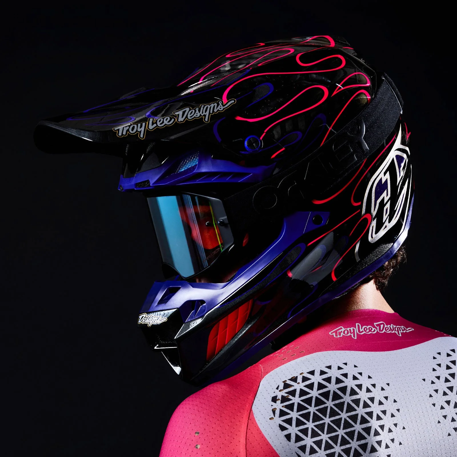 Rider in a black and purple Troy Lee Designs motocross helmet with red flame graphics